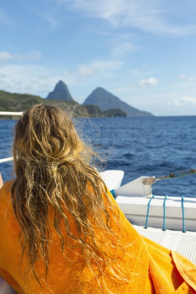 Caucasian girl sitting on boat wrapped in a towel