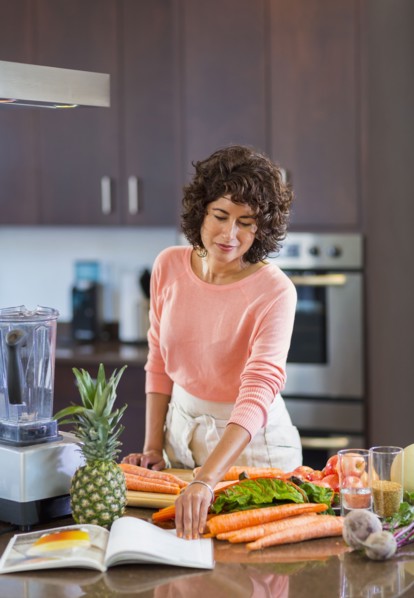 Hispanic woman reading cookbook