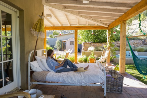 Older Caucasian woman reading books on bed on patio