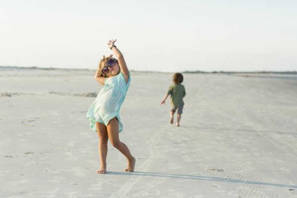 Caucasian girl posing with sunglasses on beach