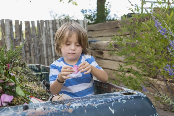 Caucasian boy sitting in truck playing with flower petal