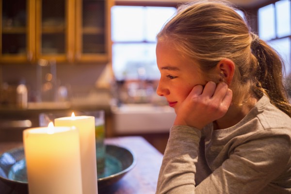 Smiling and Caucasian girl watching candles