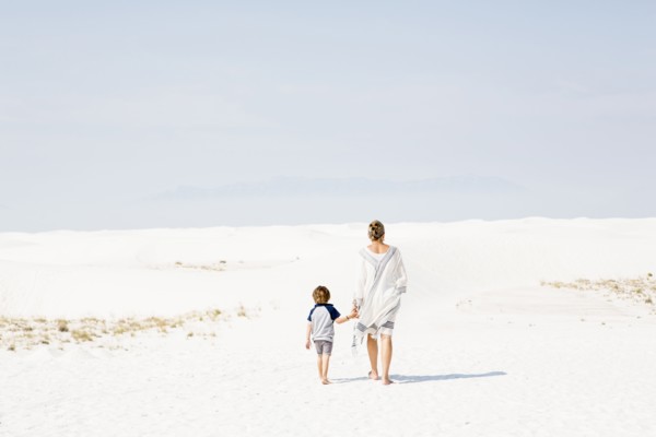 Caucasian mother and son walking in sand