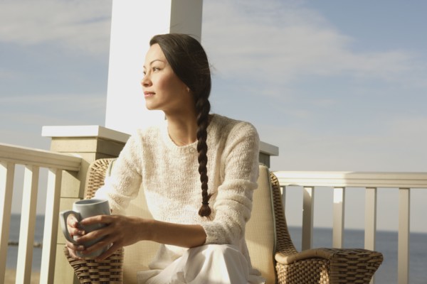 Woman having a cup of coffee on the porch