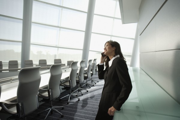 Businesswoman talking on cell phone in conference room