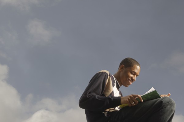 African man reading outdoors