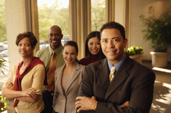Hispanic businessman in front of coworkers