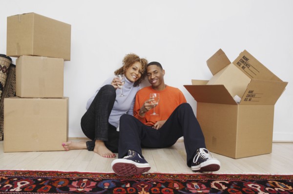 African couple with wine next to moving boxes