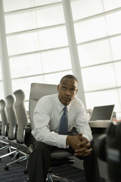 African businessman in conference room looking impatient