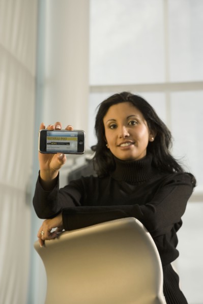 Hispanic businesswoman holding cell phone