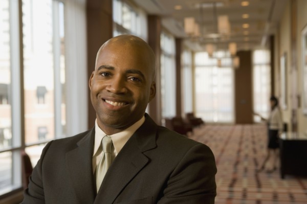 African businessman smiling in hotel corridor