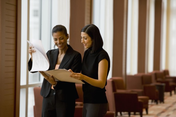 Multi-ethnic businesswoman reviewing paperwork in lobby