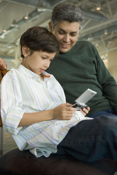 Hispanic father watching son play video game