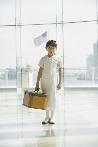 Hispanic girl with suitcase waiting in airport