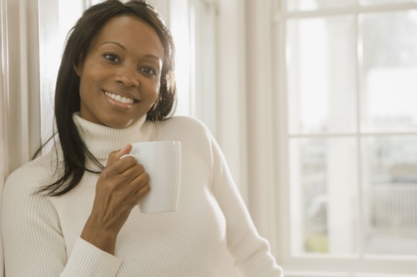 African woman holding coffee cup