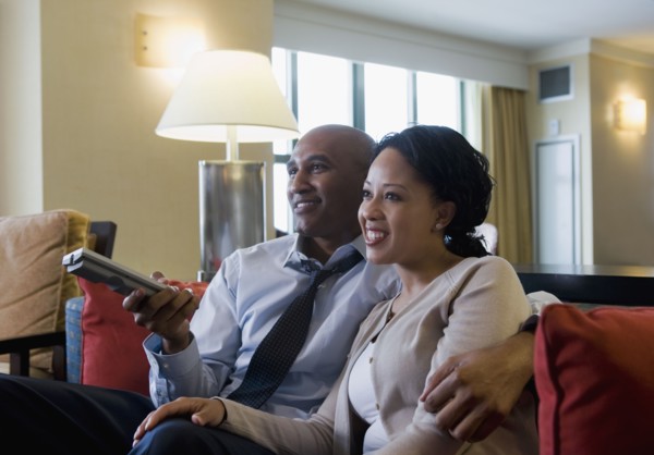 African couple watching television