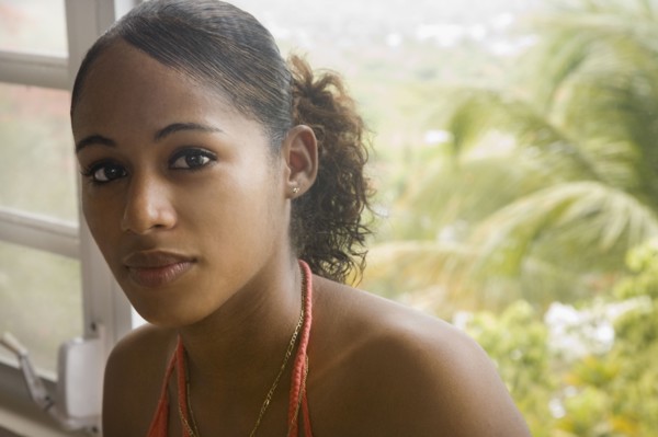 Hispanic woman sitting near window