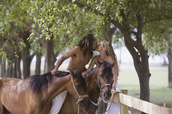 Hispanic man on horseback kissing girlfriend