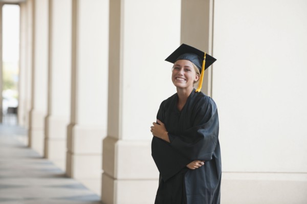Smiling graduate woman in cap and gown