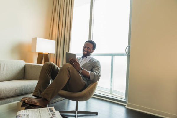 Black man using digital tablet in living room