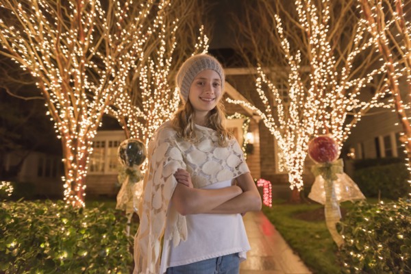 Caucasian girl posing near Christmas decorations in yard