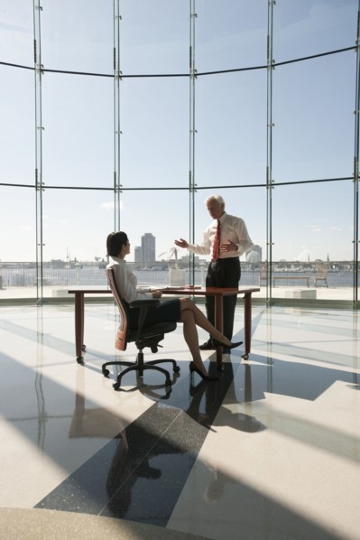 Business people working in large office with glass wall