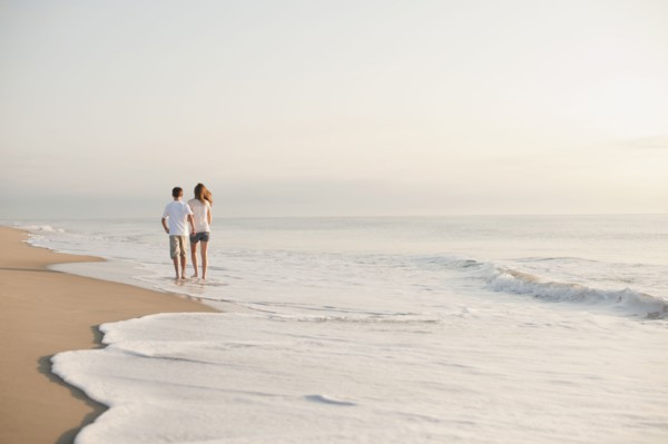 Caucasian brother and sister walking on beach