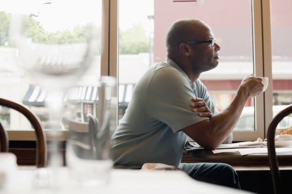 African American man drinking coffee in restaurant