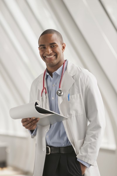 Smiling Black doctor standing with hands in pockets