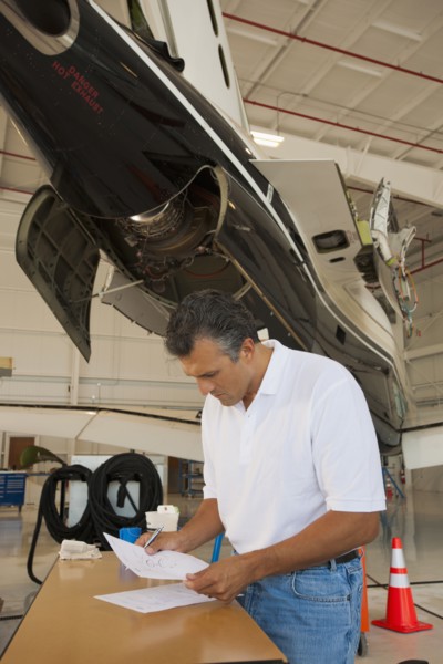 Hispanic man working in airplane hangar