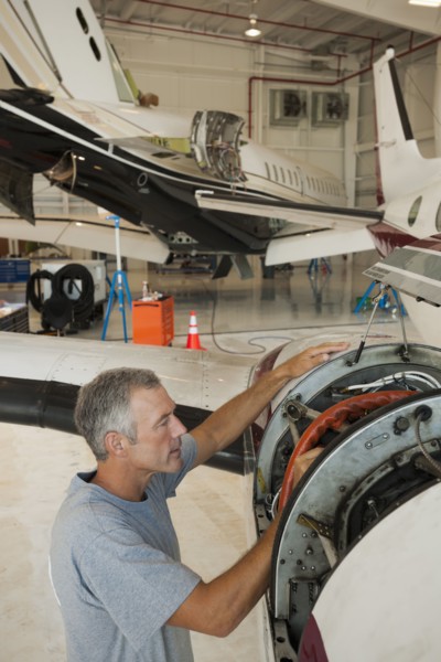 Caucasian man working in airplane hangar