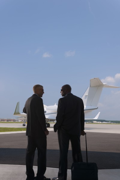 Businessmen standing on airport tarmac