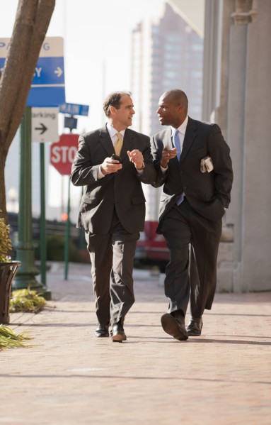 Businessmen walking together on city sidewalk