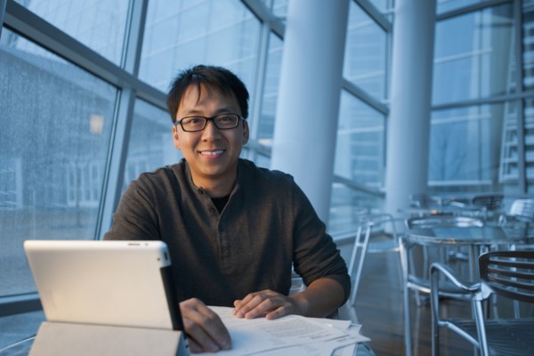 Asian businessman working with digital tablet in cafe