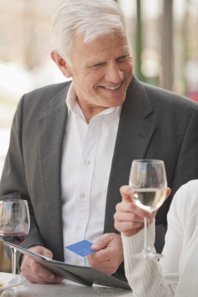 Caucasian couple drinking wine and paying bill