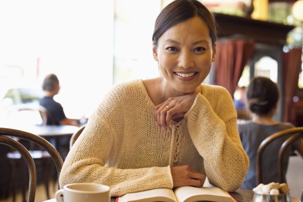 Filipino woman reading book in cafe