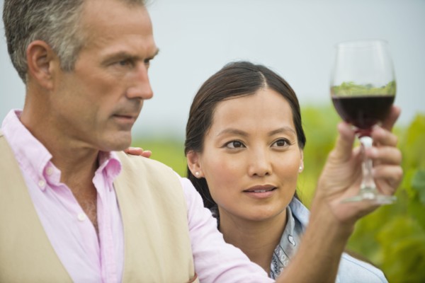 Couple tasting wine together in vineyard