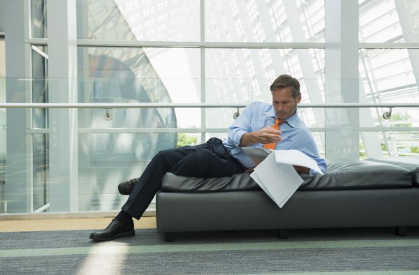 Caucasian businessman reading in lobby area