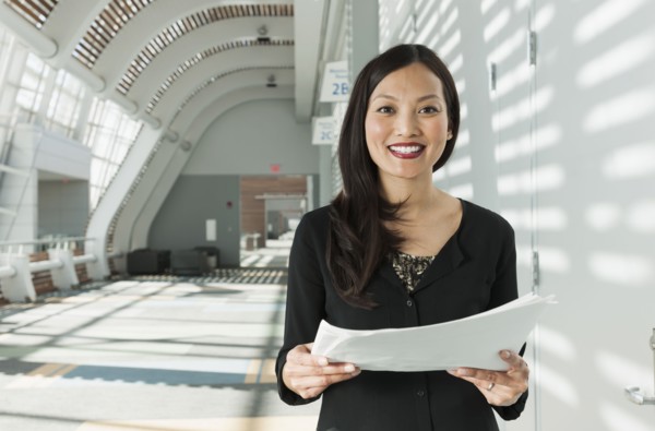 Japanese businesswoman holding papers in office