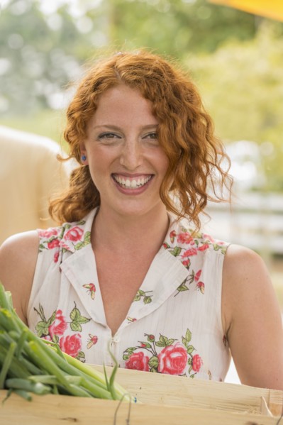 Caucasian woman carrying crate of produce