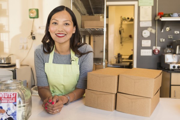 Asian baker smiling in bakery