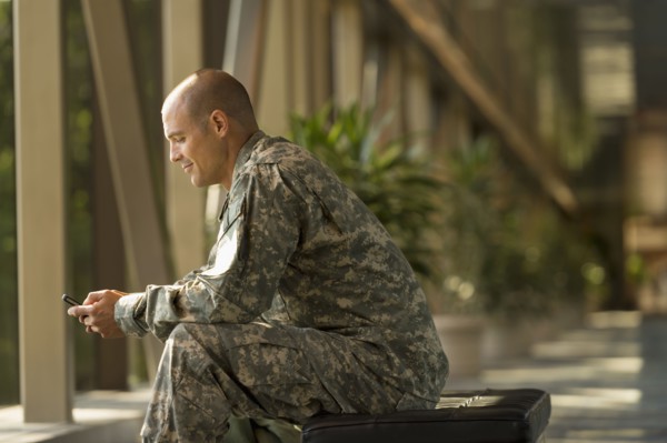 Caucasian soldier using cell phone in airport