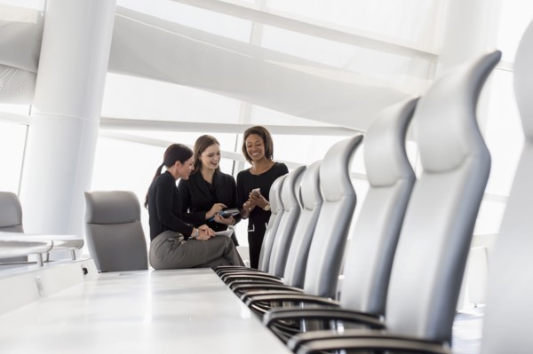 Businesswomen using cell phone in conference room