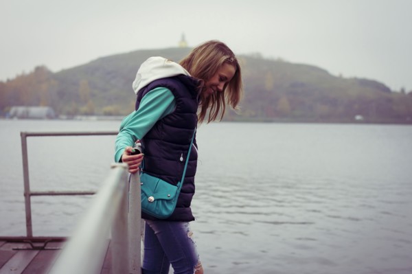 Caucasian woman standing on dock over still lake