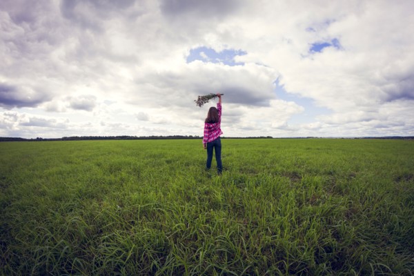 Caucasian girl playing in grassy field