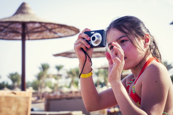 Caucasian girl photographing outdoors