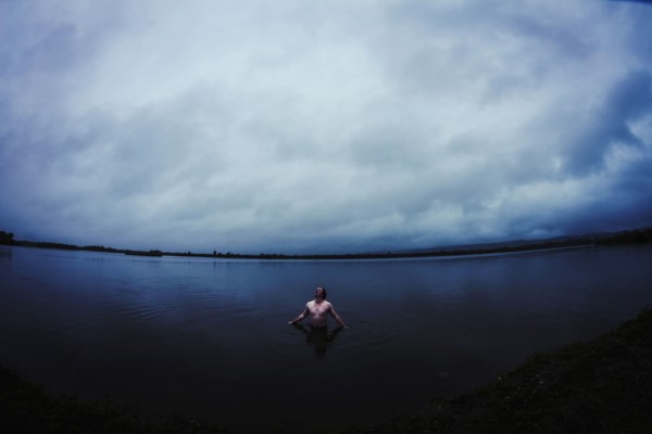 Caucasian man standing in still remote lake