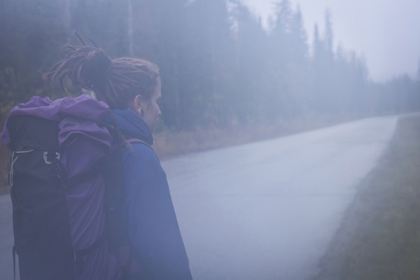 Caucasian hiker walking on remote road