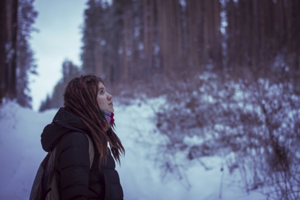 Caucasian woman standing in snowy forest