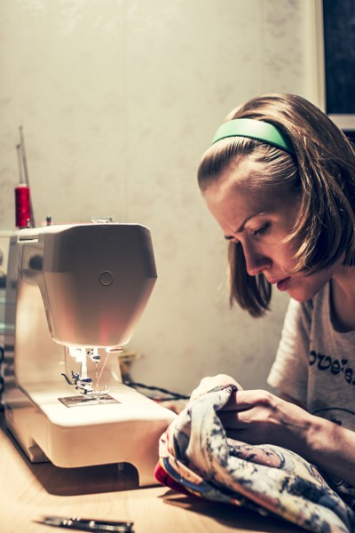 Caucasian woman using sewing machine
